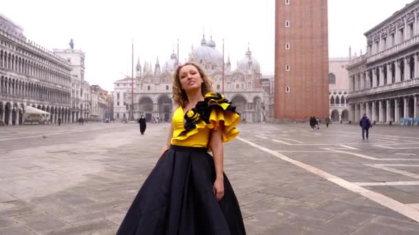 Jolie dame en robe longue pose à la place Saint-Marks déserte — Video