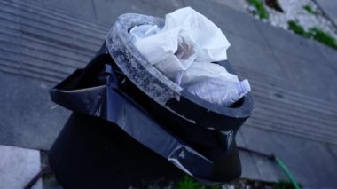 Siyah çöp tenekesini siyah plastik torba ve çöp ile doldurdum.