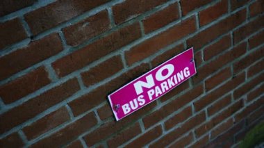 Duvarda pembe renkli otobüs parkı tabelası yok.