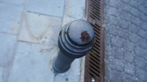 Застарілий обмежувальний стовп, розташований на тротуарі коричневим дренажем — стокове відео
