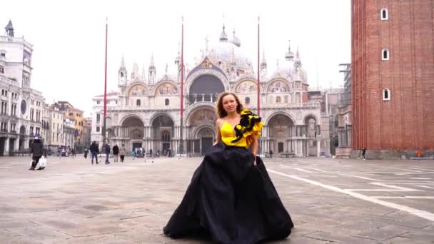 Model wearing designer dress walks along Venice city square — Stock Video