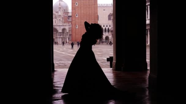 Λεπτή γυναικεία σιλουέτα με βραδινό φόρεμα που ποζάρει ανάμεσα σε στήλες — Αρχείο Βίντεο
