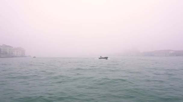 Pequeñas embarcaciones a motor navegan en agua de laguna veneciana en niebla — Vídeo de stock