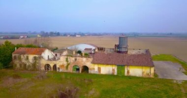 Terk edilmiş çiftlik evi, küçük kasaba yakınlarındaki tarlalar ve ağaçların arasında.