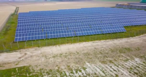 Panouri solare rânduri pe gazon cu gard între câmpuri goale — Videoclip de stoc