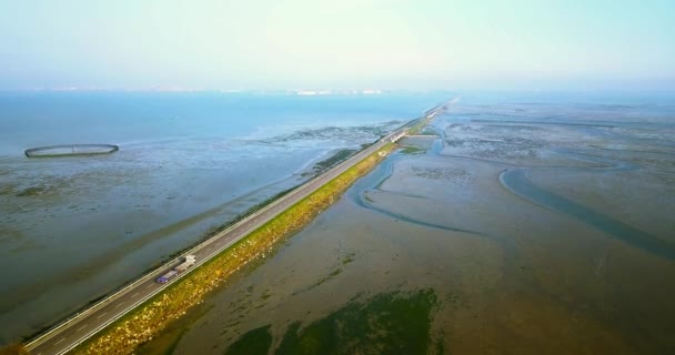 Os carros dirigem à cidade na estrada longa que cruza a lagoa venetian — Vídeo de Stock