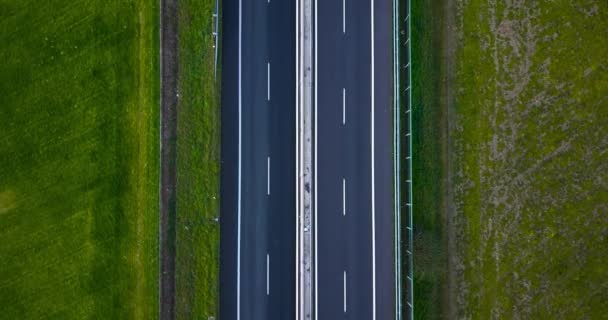 Bilar kör på motorvägen på landsbygden förbi småstad — Stockvideo