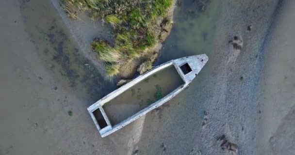 Gebroken motorboot romp door struiken op vervuild zandland — Stockvideo