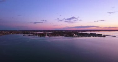 Mor Venedik lagünü, günbatımı altında büyük bir şehre karşı.