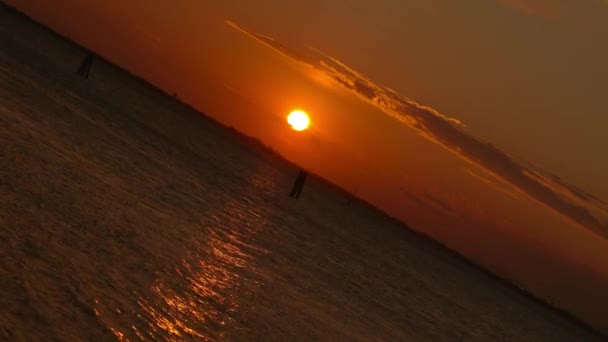 Silhouetten van de pijlerwaterweg tussen grenzeloze lagune bij zonsondergang — Stockvideo