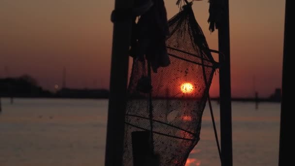 Rede de pesca pendurada ao pôr do sol sobre a lagoa — Vídeo de Stock