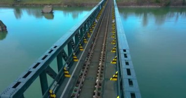 Tren rayları çelik bir köprüden geçiyor.