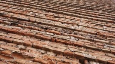 Şehir merkezinde çatlak olan geniş turuncu tuğlalı duvar resmi.