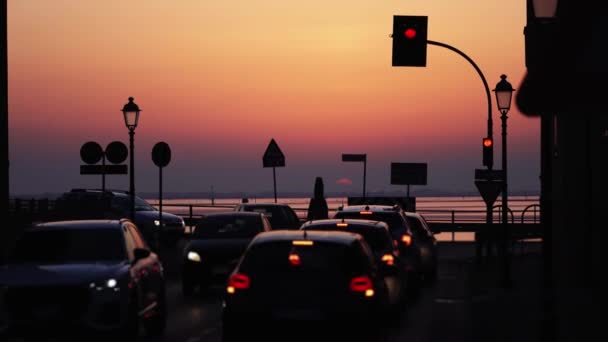 Carros parados em luzes vermelhas na cidade ao pôr do sol — Vídeo de Stock