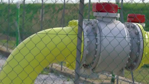 Um grande tubo amarelo atrás de uma cerca de malha — Vídeo de Stock