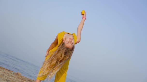 Esnek ve eğilmiş bir kız bir limon düşürür — Stok video