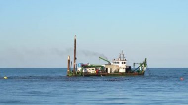 Denizdeki gemi suyun altındaki borularla kumu rendeliyor.