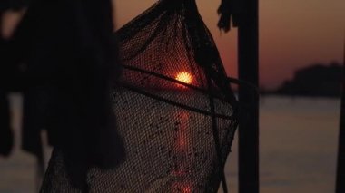 Gün batımında gölün üzerinde asılı duran balık ağı.