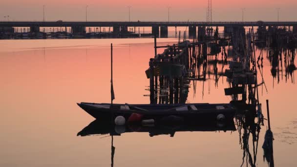 En träbåt och fiskebåt vid solnedgången — Stockvideo