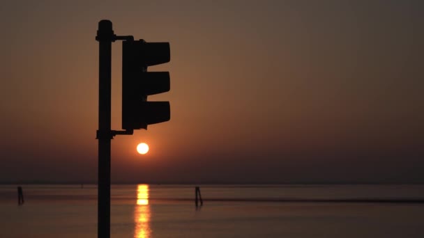 Silueta del semáforo al atardecer sobre el lago — Vídeos de Stock