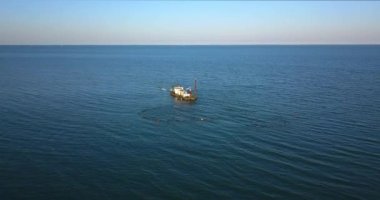 Bir tekne denizin ortasında bazı işler yapıyor.