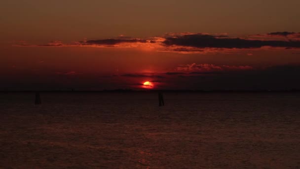 Темне море під сонячним диском ховається за хмарними силуетами — стокове відео