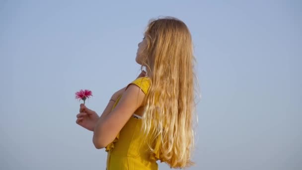 Teenager beugt sich mit Blume in der Hand in Zeitlupe vor — Stockvideo