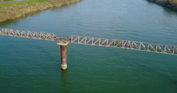 Una tubería de metal oxidado a través del río — Vídeos de Stock