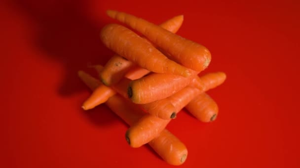Um monte de cenouras na mesa vermelha — Vídeo de Stock