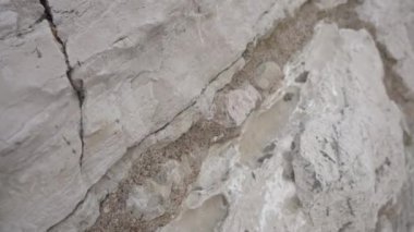 Ön planda antik kayalardan oluşan bir duvar.