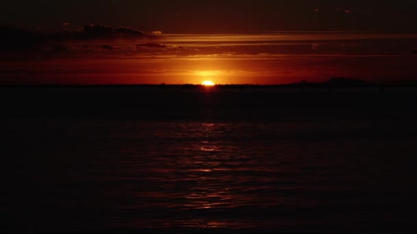 Puesta de sol refleja en laguna creando sendero de luz solar — Vídeos de Stock