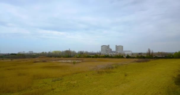 Moving forward on a green field with a large building in the background — Stock Video