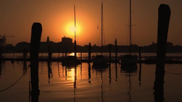 Silueta bărcii cu pânze pe apă la apusul soarelui în Chioggia — Videoclip de stoc