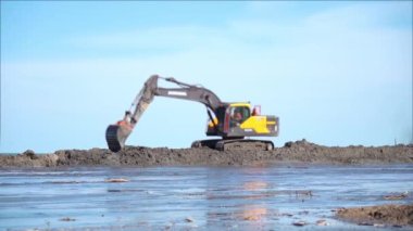Kazı makinesi kumlu sahillerin besinleri üzerinde çalışıyor.