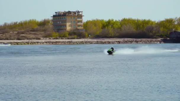 Un jet ski attraversa il mare di fronte a una diga — Video Stock