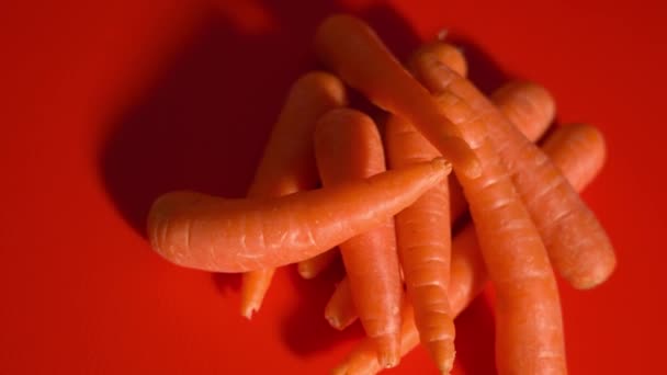Купка моркви на червоному столі — стокове відео
