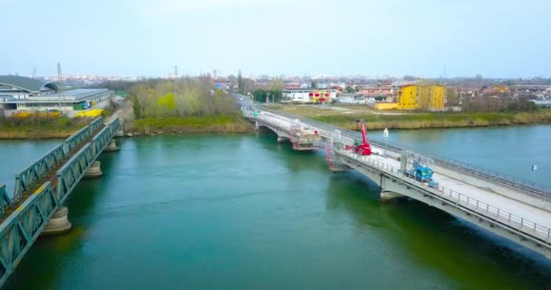 Een brug over de rivier met een deel in aanbouw — Stockvideo