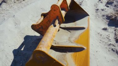 Kazı kovası kumda dinleniyor.