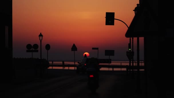 Auto 's rijden voorbij bij zonsondergang. — Stockvideo
