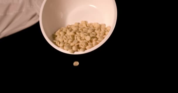Potongan cokelat putih jatuh dalam gerakan lambat dari piring — Stok Video