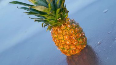 Güzel yansımalarla ıslak plaja yerleştirilmiş ananas.