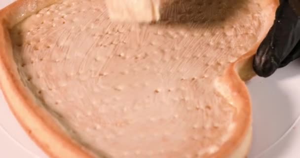 Herzförmige Torte ist mit Sahne überzogen — Stockvideo