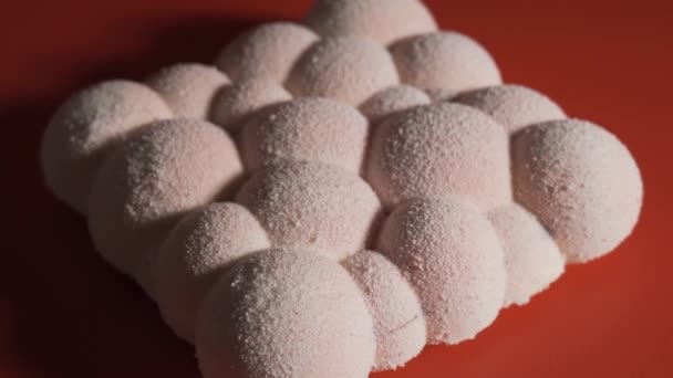 Sabroso pastel estallidos de bolas blancas en la mesa negra — Vídeos de Stock