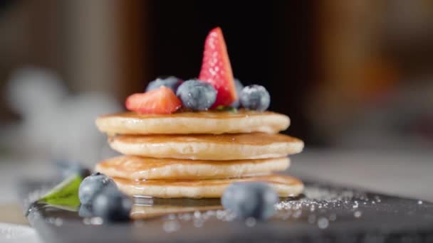 Gehakte aardbeien worden bovenop pannenkoeken gelegd — Stockvideo