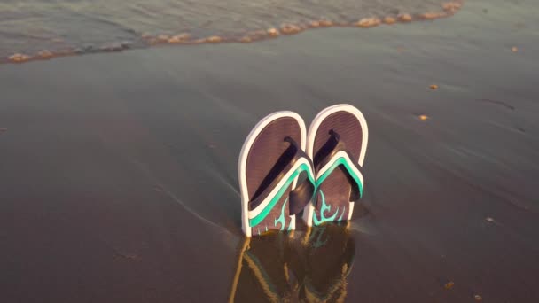 Chanclas en la arena de la playa junto al mar — Vídeos de Stock