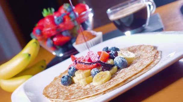 Chocolate quente é derramado sobre panquecas com frutas — Vídeo de Stock