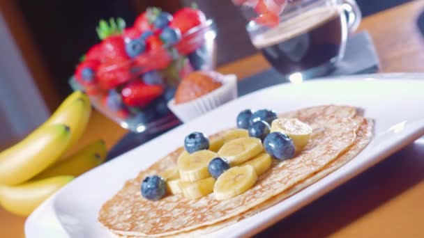 Ízletes reggeli palacsinta és gyümölcs az asztalon — Stock videók
