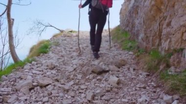Kayalık dağda kadın uçurumun kenarında yürür.