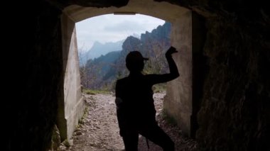 Kız kaslarını esnetiyor ve dağlarda bir mağarada antrenman yapıyor.