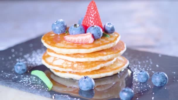 Hackade jordgubbar läggs ovanpå pannkakor — Stockvideo